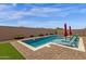 Backyard pool with lounge chairs and umbrellas, set against a private walled perimeter at 11334 S 52Nd Ln, Laveen, AZ 85339