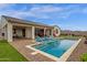 Backyard pool area featuring brick pavers, a built-in pool and several deck chairs under red umbrellas at 11334 S 52Nd Ln, Laveen, AZ 85339