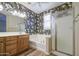 An elegant bathroom featuring a tub, shower, double vanity, and decorative floral wallpaper at 1143 S Annie Ln, Gilbert, AZ 85296