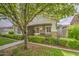 Attractive home featuring a charming porch, mature tree, and manicured landscaping at 1143 S Annie Ln, Gilbert, AZ 85296
