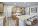 A well-lit kitchen features granite countertops, stainless steel appliances, and a breakfast bar with seating at 1143 S Annie Ln, Gilbert, AZ 85296