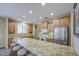 Spacious kitchen features granite counters, stainless steel refrigerator, and a large island with seating at 1143 S Annie Ln, Gilbert, AZ 85296