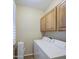 This is a laundry room featuring a white washer and dryer with wood cabinets at 1143 S Annie Ln, Gilbert, AZ 85296