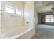 Bright bathroom featuring a soaking tub next to an open door into another room at 120 N Pottebaum Rd, Casa Grande, AZ 85122
