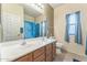 Bright bathroom featuring a double sink vanity, large mirror, and bathtub with blue shower curtain at 120 N Pottebaum Rd, Casa Grande, AZ 85122