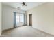 Spacious bedroom with neutral carpet, ceiling fan, window, and sliding door closet at 120 N Pottebaum Rd, Casa Grande, AZ 85122