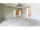Spacious bedroom featuring neutral carpet, ceiling fan, and an open door to the hallway at 120 N Pottebaum Rd, Casa Grande, AZ 85122