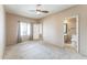 Bedroom features neutral carpet, ceiling fan, and ensuite bathroom at 120 N Pottebaum Rd, Casa Grande, AZ 85122