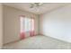 Bedroom features neutral carpet, white walls and a window with pink curtains at 120 N Pottebaum Rd, Casa Grande, AZ 85122