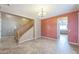Living room area featuring tiled floors, an adjacent staircase, and a view into the kitchen at 120 N Pottebaum Rd, Casa Grande, AZ 85122
