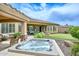 Backyard showcasing a rejuvenating hot tub, outdoor lounge, synthetic putting green, and desert landscape elements for relaxed living at 13353 W Gloria Ln, Peoria, AZ 85383