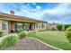 Inviting backyard with a synthetic putting green, covered patio, and neatly arranged desert landscaping for serene outdoor enjoyment at 13353 W Gloria Ln, Peoria, AZ 85383