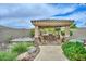 Outdoor entertainment area featuring a spa, outdoor kitchen with seating, and lush landscaping creating a resort-like atmosphere at 13353 W Gloria Ln, Peoria, AZ 85383