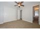Cozy bedroom with ceiling fan, closet, and view into the bathroom at 13353 W Gloria Ln, Peoria, AZ 85383