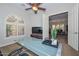 Bright office space featuring a modern glass desk and an arched window with plantation shutters at 13353 W Gloria Ln, Peoria, AZ 85383