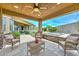 Serene outdoor patio with a hot tub, barbecue area, and comfortable seating, enhanced by a ceiling fan for year-round enjoyment at 13353 W Gloria Ln, Peoria, AZ 85383