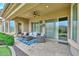 Cozy outdoor patio area with comfortable seating, ceiling fan, and travertine floors at 13353 W Gloria Ln, Peoria, AZ 85383