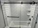 Bathroom featuring a white tiled tub and shower with a glass door, and black fixtures at 1449 E Highland Ave # 25, Phoenix, AZ 85014