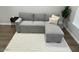 Comfortable gray sofa with ottoman, complemented by a stylish rug and natural lighting at 1449 E Highland Ave # 25, Phoenix, AZ 85014