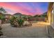 Serene backyard view with desert landscaping, a sparkling pool, and picturesque mountain views at sunset at 14523 E Charter Oak Dr, Scottsdale, AZ 85259