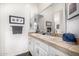 Bathroom featuring double sinks, tan tile countertops, white cabinets, and decor at 14523 E Charter Oak Dr, Scottsdale, AZ 85259
