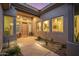 Inviting front entrance with a wooden door, desert landscaping, and ample lighting, creating a warm and stylish arrival experience at 14523 E Charter Oak Dr, Scottsdale, AZ 85259