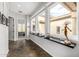 Bright hallway featuring stone floors, high ceilings, unique wall decor and several windows offering natural light at 14523 E Charter Oak Dr, Scottsdale, AZ 85259