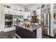Modern kitchen features stainless steel appliances, a center island, and white cabinetry at 14523 E Charter Oak Dr, Scottsdale, AZ 85259