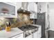 Close-up of the kitchen shows a chef-grade cooktop and decorative tile backsplash at 14523 E Charter Oak Dr, Scottsdale, AZ 85259