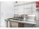 Close up of the laundry room sink, white backsplash, and white appliances at 14523 E Charter Oak Dr, Scottsdale, AZ 85259