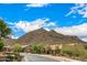 Scenic street view in a desert community with lush landscaping and views of the surrounding mountains at 14523 E Charter Oak Dr, Scottsdale, AZ 85259