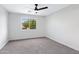 Bright bedroom with a ceiling fan, gray carpet and large window at 1563 S Longspur Ln, Gilbert, AZ 85296