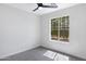 Bright bedroom with gray carpet, ceiling fan, and window showcasing the neighborhood at 1563 S Longspur Ln, Gilbert, AZ 85296