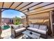 This covered backyard patio features a pool with waterfall and comfortable outdoor furniture at 15743 N 165Th Ln, Surprise, AZ 85388