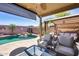 This covered backyard has a pool, waterfall, and patio furniture, perfect for outdoor living at 15743 N 165Th Ln, Surprise, AZ 85388
