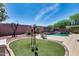Landscaped backyard featuring a lush lawn, a pool with a waterfall, mature trees, and a lounge area at 15743 N 165Th Ln, Surprise, AZ 85388