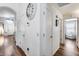 Bright hallway with hardwood floors, white doors, and decorative clock at 15743 N 165Th Ln, Surprise, AZ 85388