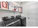 Modern laundry room equipped with black washer and dryer, overhead storage at 15743 N 165Th Ln, Surprise, AZ 85388