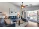 Bright living room with stylish furniture, ceiling fan, and sliding door access to a beautiful pool at 15743 N 165Th Ln, Surprise, AZ 85388