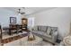 Cozy living room featuring a gray sofa, patterned ottoman, and dining table with wood flooring at 15743 N 165Th Ln, Surprise, AZ 85388