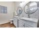This main bathroom features double sinks with mirrors, quartz countertops, and luxury vinyl plank flooring at 15743 N 165Th Ln, Surprise, AZ 85388