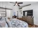 This main bedroom features a ceiling fan, television, and a barn door leading to the main bathroom at 15743 N 165Th Ln, Surprise, AZ 85388