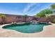 Private pool features rock waterfall, lush greenery, and a stone privacy wall, creating a serene retreat at 15743 N 165Th Ln, Surprise, AZ 85388
