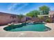 Sparkling pool surrounded by a rock waterfall, lush landscaping, and an ornate privacy wall at 15743 N 165Th Ln, Surprise, AZ 85388