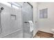 This shower features a glass door, built-in bench, shower head, and tile flooring at 15743 N 165Th Ln, Surprise, AZ 85388