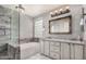 Luxurious bathroom featuring a soaking tub, tiled shower, double sinks, granite vanity and designer mirror at 16017 S 12Th Pl, Phoenix, AZ 85048