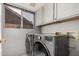 Laundry room featuring side-by-side washer and dryer under white cabinets at 16017 S 12Th Pl, Phoenix, AZ 85048
