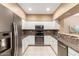 Modern kitchen features white cabinets, stainless steel appliances and mosaic tile backsplash at 16626 E Westby Dr # 108, Fountain Hills, AZ 85268