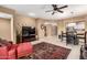 Cozy living room with a red chaise lounge, tile floor, and open access to the dining area at 16626 E Westby Dr # 108, Fountain Hills, AZ 85268