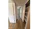 Hallway features neutral paint, closet with shelving, and wood-look flooring at 170 E Guadalupe Rd # 173, Gilbert, AZ 85234